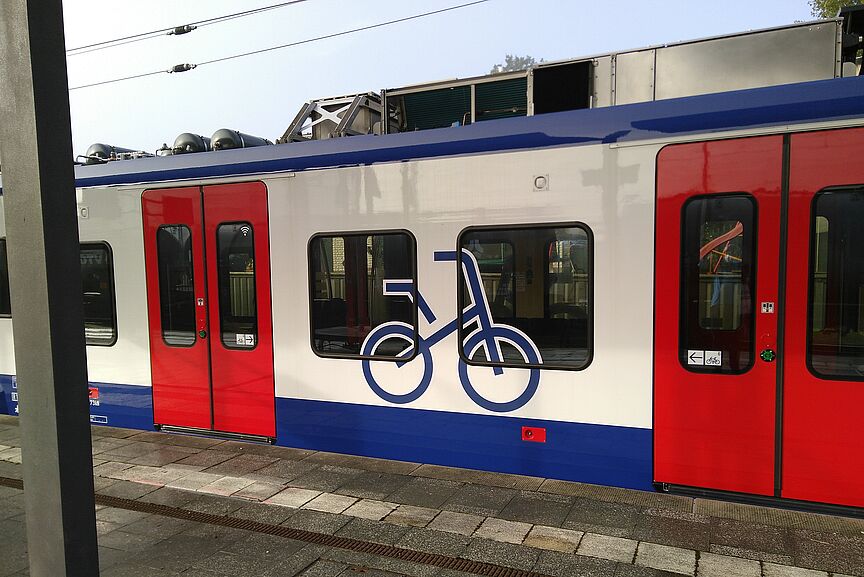 S-Bahn des GVH am Bahnsteig mit großem Fahrradsymbol im Fensterbereich zwischen den Einstiegstüren zum Mehrzweckabeil