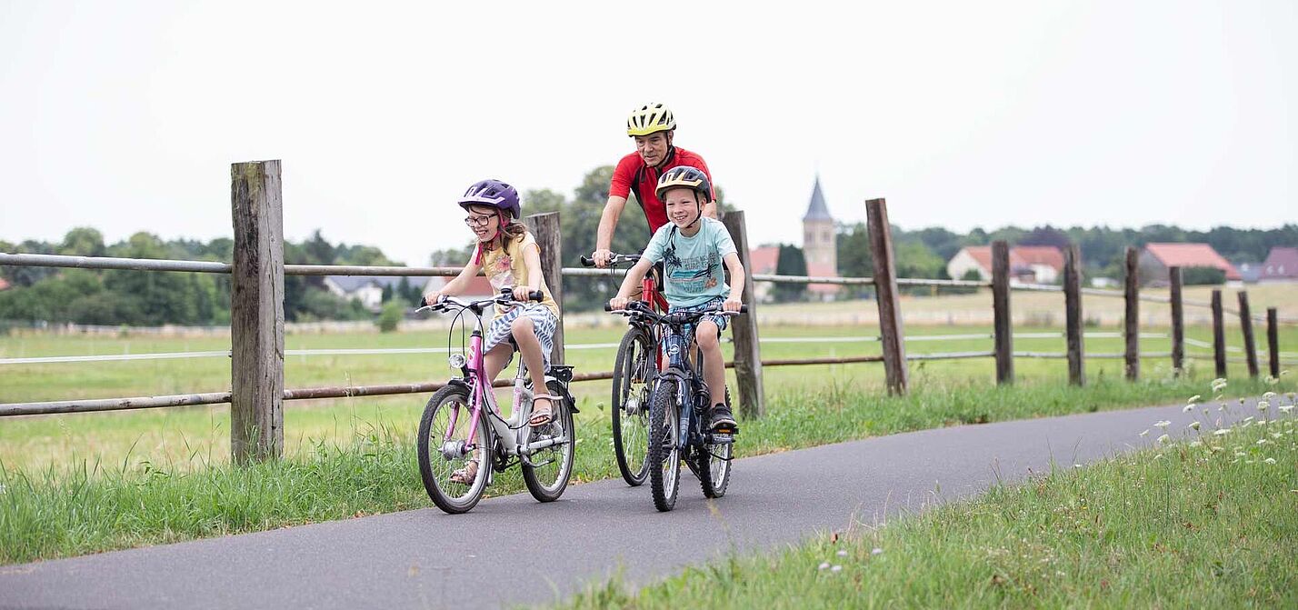 Opa mit Kindern auf Radtour Opa mit zwei Kindern auf Fahrradweg im ländlicher Umgebung